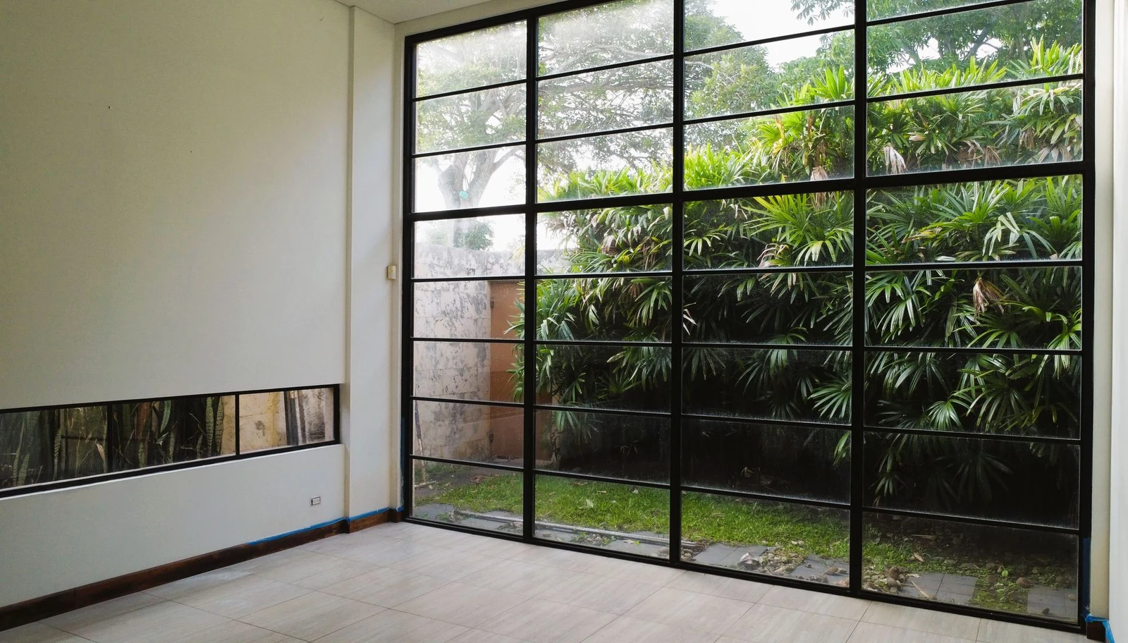 Sala a doble altura con ventanal al jardín — casa en alquiler en San Rafael de Escazú