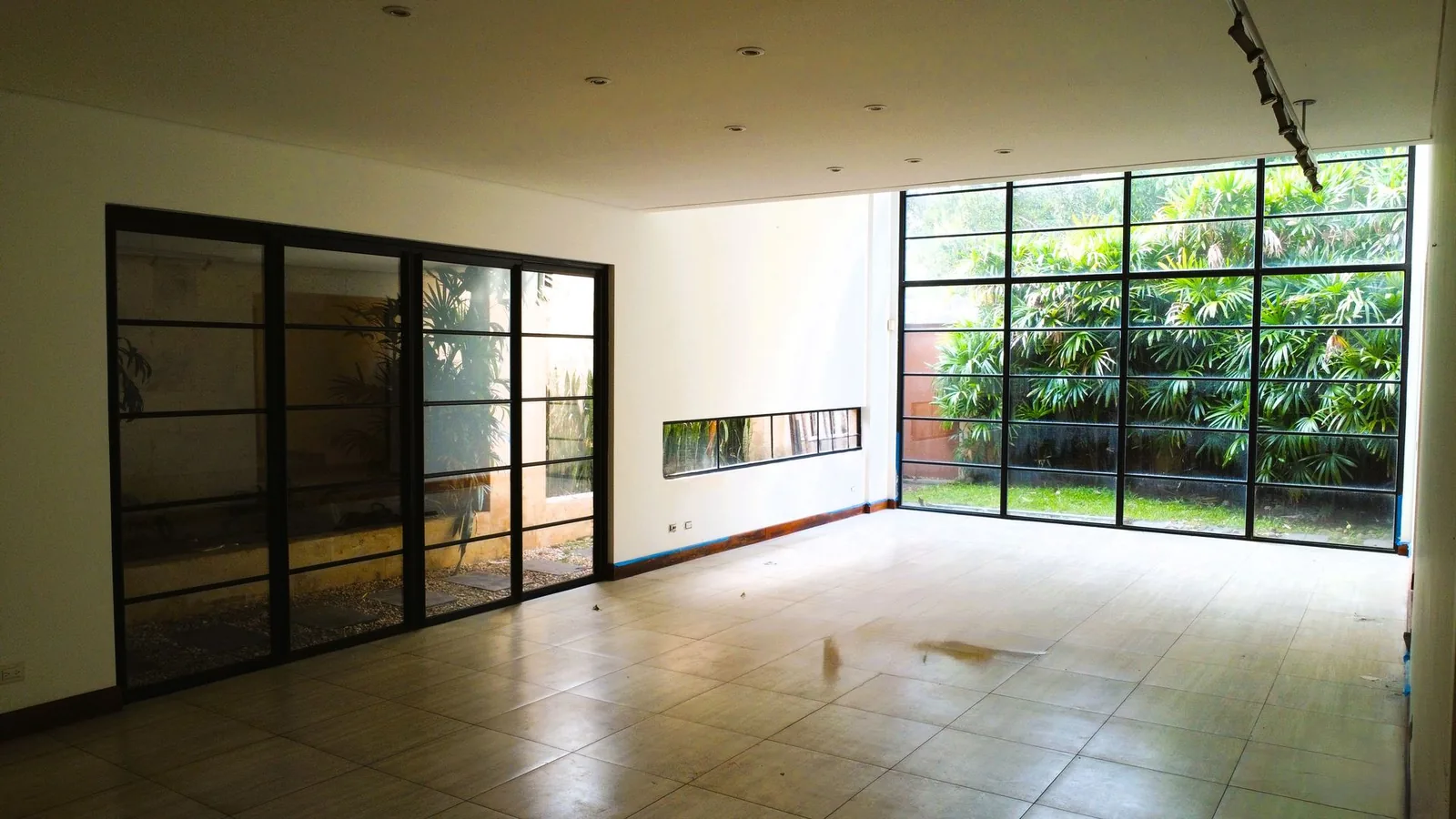 Sala con ventanal al patio privado — casa en alquiler en San Rafael de Escazú