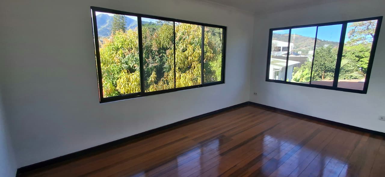 Dormitorio secundario con walk-in closet y vista a las montañas de Escazú